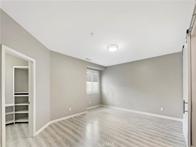 spare room with visible vents, light wood-style floors, and baseboards