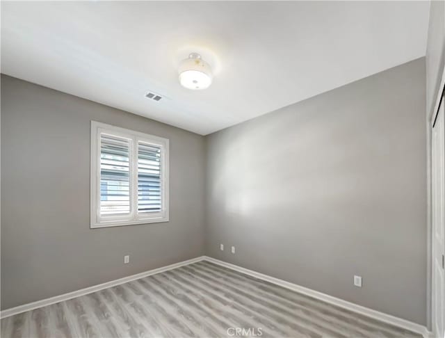 spare room with visible vents, baseboards, and light wood-style floors