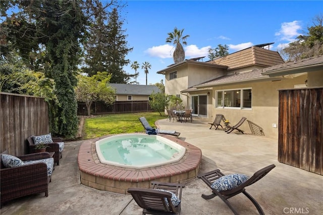 exterior space featuring a fenced backyard, an outdoor hangout area, and an outdoor hot tub