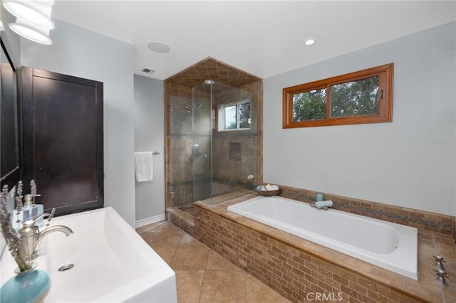 full bathroom featuring tile patterned flooring, a shower stall, a bath, and a sink