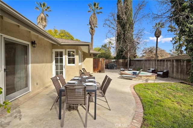 view of patio with an outdoor hot tub and a fenced backyard