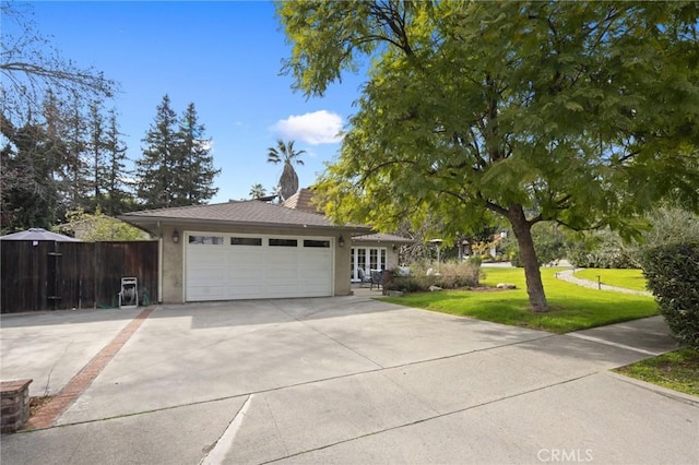 view of front of house featuring stucco siding, an attached garage, concrete driveway, and a front yard
