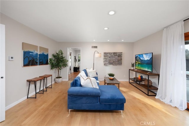 living area with recessed lighting, light wood-type flooring, baseboards, and visible vents