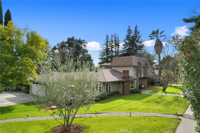 view of front of house featuring a front lawn, a garage, and stucco siding