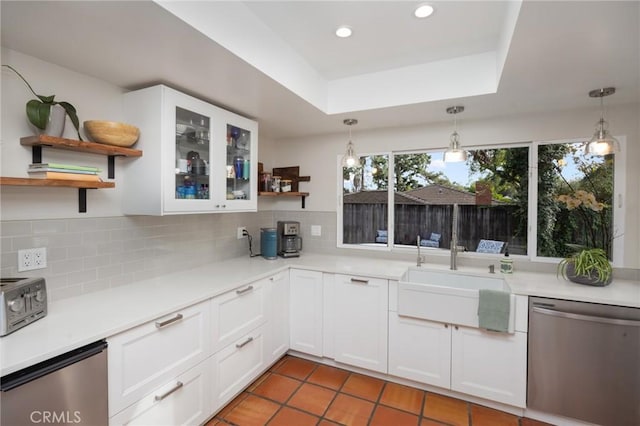 kitchen featuring open shelves, a tray ceiling, a sink, decorative backsplash, and dishwasher