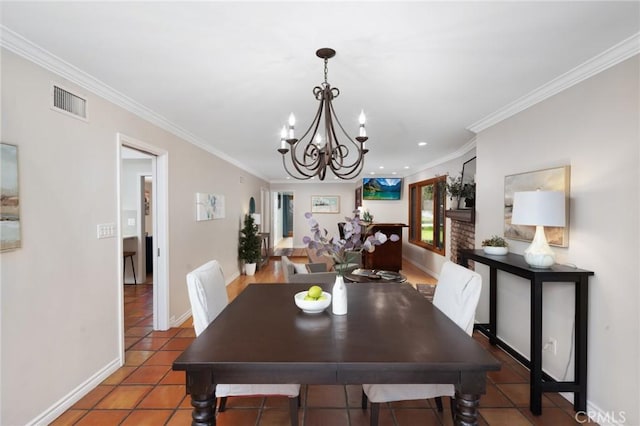 dining room with a notable chandelier, baseboards, visible vents, and ornamental molding