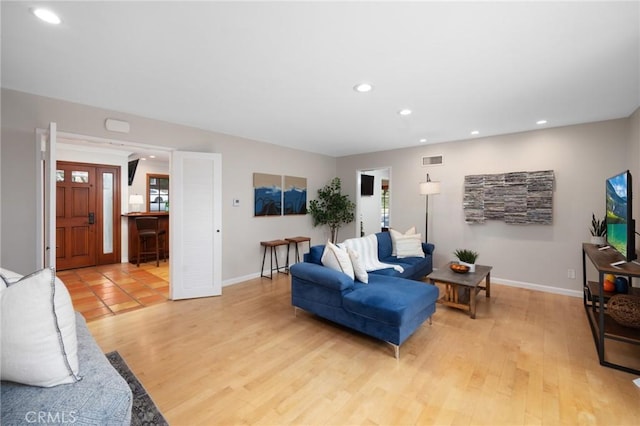 living room featuring recessed lighting, visible vents, baseboards, and light wood-style floors