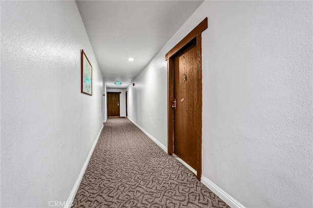 corridor with carpet flooring and baseboards