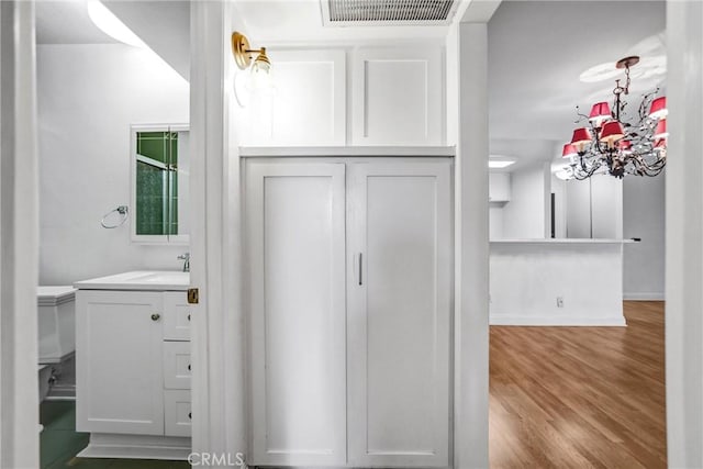 bathroom featuring vanity, wood finished floors, visible vents, baseboards, and toilet