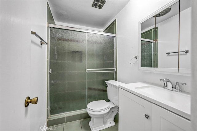 bathroom with vanity, toilet, a stall shower, and tile patterned flooring