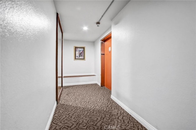 hall with baseboards and carpet floors