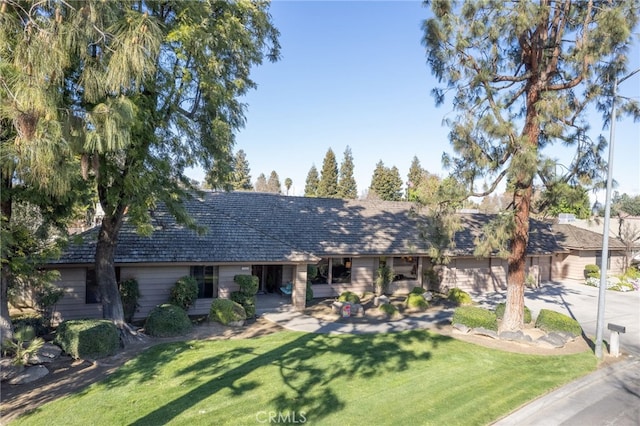 view of front of house featuring concrete driveway and a front lawn