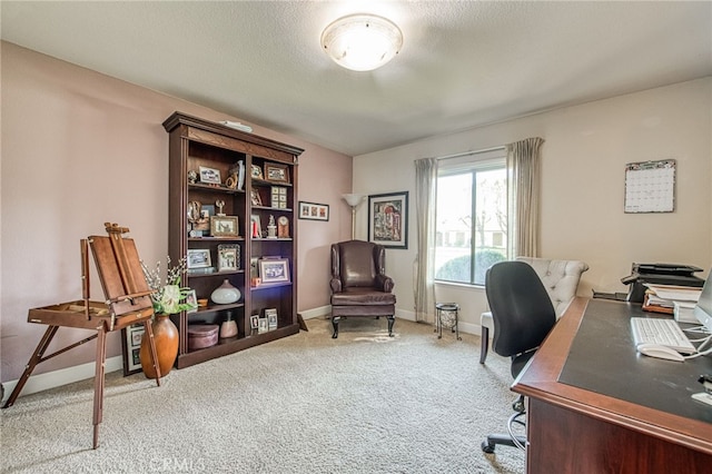 carpeted office space featuring a textured ceiling and baseboards