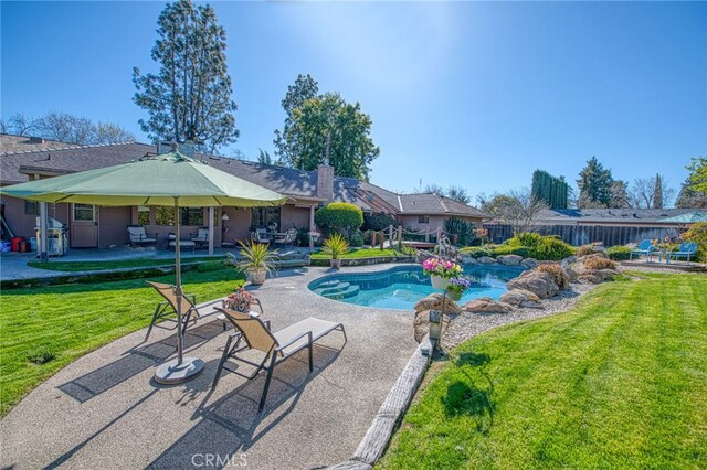 view of swimming pool with a patio area, a lawn, a fenced in pool, and fence