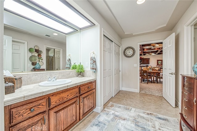 bathroom featuring vanity, visible vents, baseboards, tile patterned flooring, and a closet