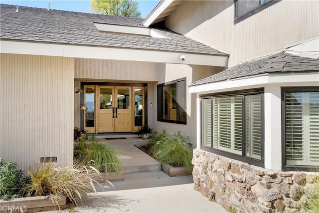 doorway to property with a shingled roof