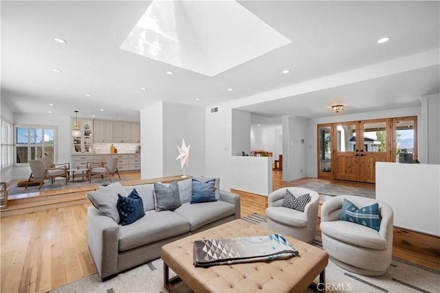 living room with a wealth of natural light, recessed lighting, and light wood-style floors