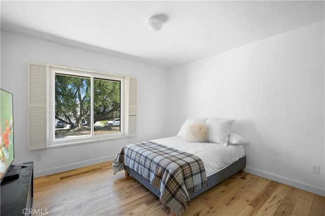 bedroom with baseboards and wood finished floors