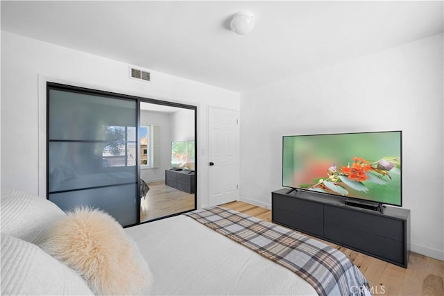 bedroom with visible vents, baseboards, and wood finished floors