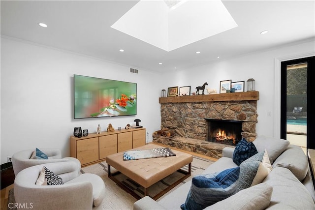 living room with visible vents, a skylight, recessed lighting, a fireplace, and crown molding