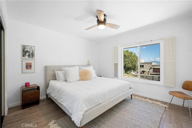 bedroom featuring a ceiling fan, wood finished floors, and baseboards