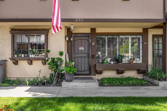 doorway to property featuring stucco siding