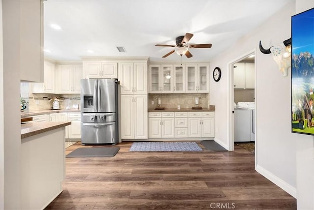 kitchen featuring backsplash, dark wood-style flooring, stainless steel fridge with ice dispenser, and washer and clothes dryer