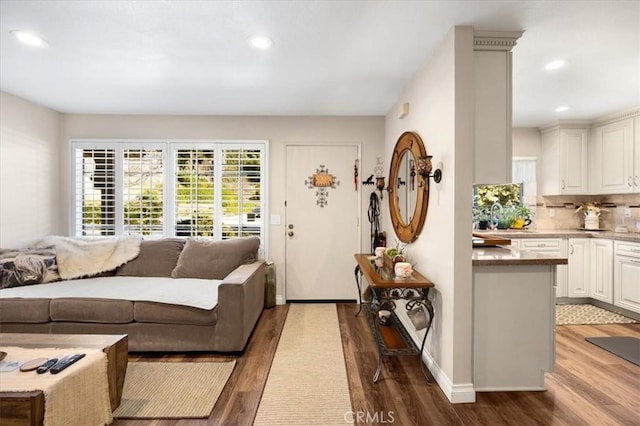 living room with recessed lighting, baseboards, and wood finished floors