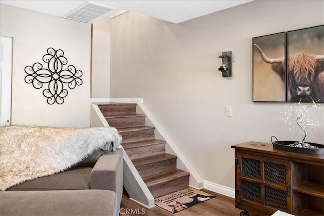 stairs featuring visible vents, baseboards, and wood finished floors