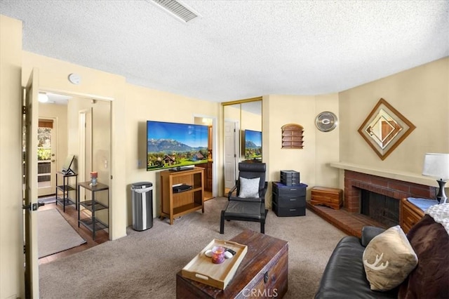 carpeted living room with visible vents, a textured ceiling, and a brick fireplace