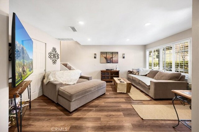 living room with dark wood-type flooring, stairway, recessed lighting, and visible vents