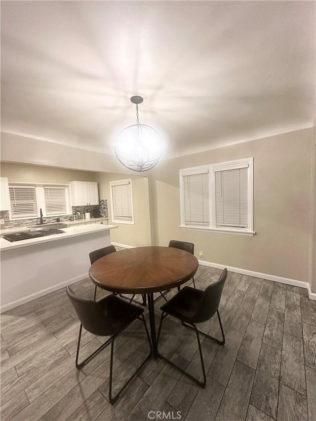 dining space featuring dark wood-style floors and baseboards