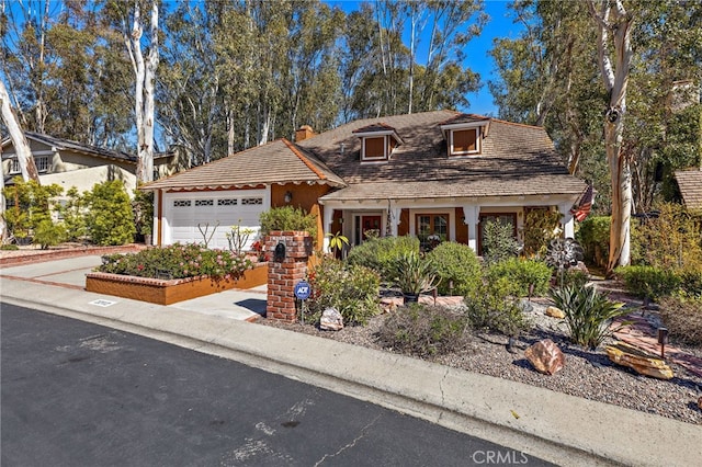 view of front facade with a garage, driveway, and a chimney