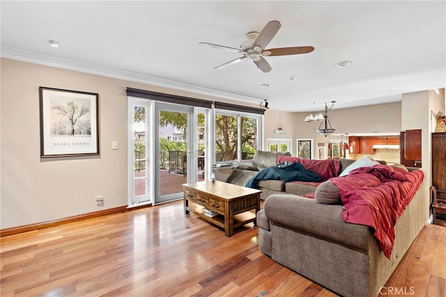 living area with light wood-style flooring, baseboards, crown molding, and a ceiling fan