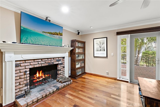 unfurnished living room with crown molding, a brick fireplace, light wood-style flooring, and baseboards