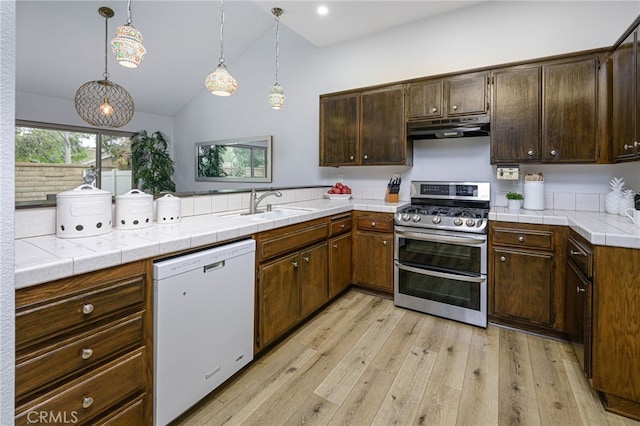 kitchen featuring under cabinet range hood, dishwasher, range with two ovens, a peninsula, and light wood-style floors