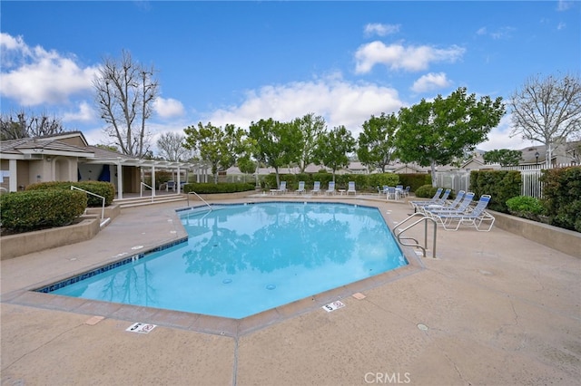 community pool with a patio and fence