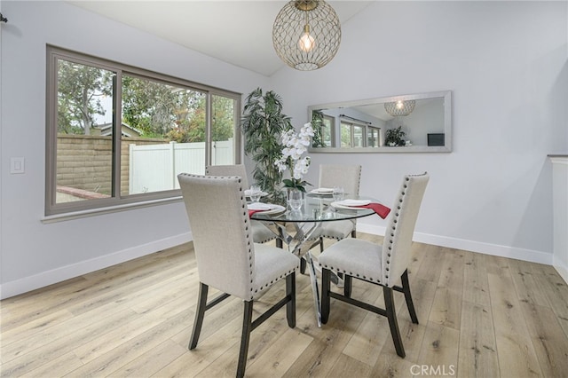 dining area with lofted ceiling, baseboards, and wood-type flooring