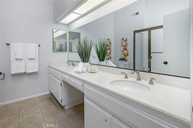 bathroom with double vanity, visible vents, toilet, and a sink