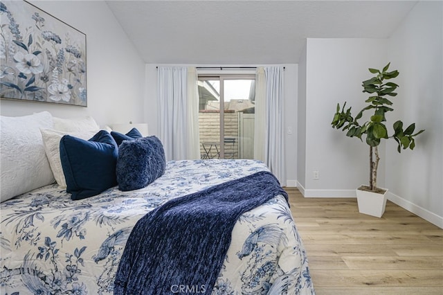 bedroom with lofted ceiling, access to outside, baseboards, and light wood-type flooring