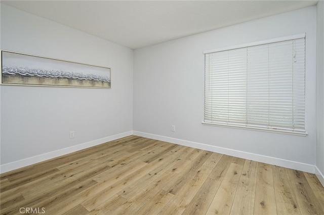 empty room featuring light wood-style floors and baseboards