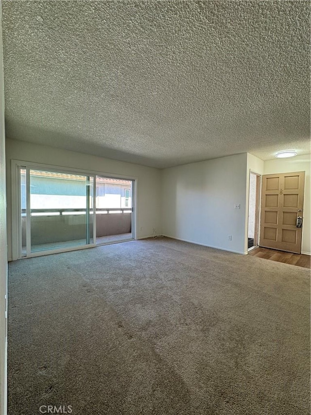 carpeted spare room featuring a textured ceiling