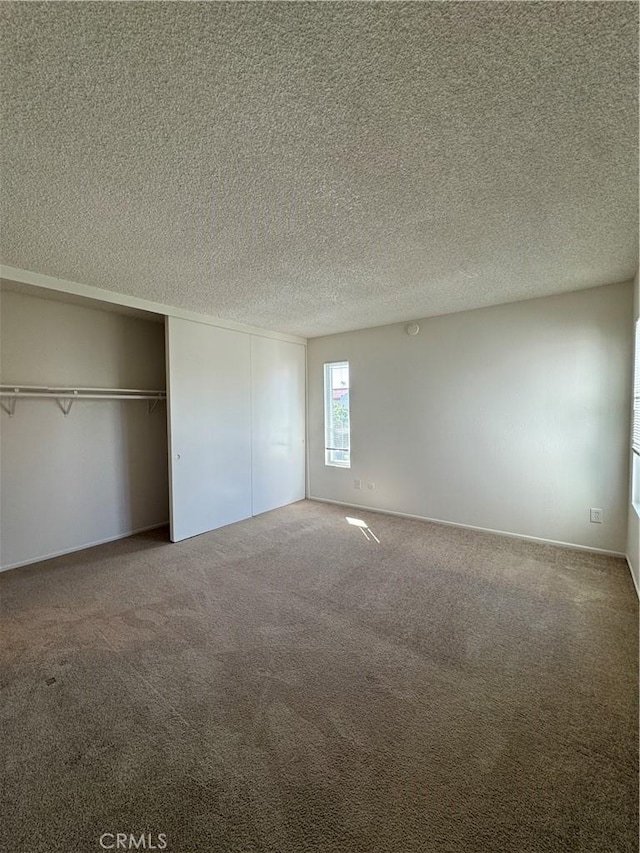 unfurnished bedroom with a closet, carpet, and a textured ceiling