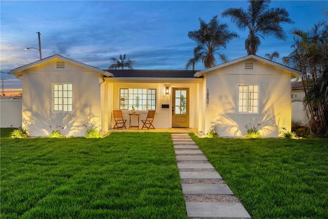 view of front of property featuring a front lawn and stucco siding