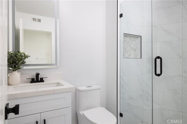 full bath with vanity, a shower stall, toilet, and visible vents