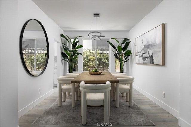 dining space with baseboards and wood finished floors