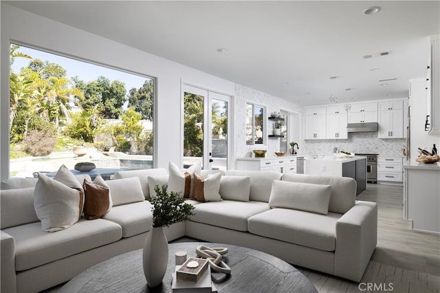 living room with visible vents, recessed lighting, and wood finished floors