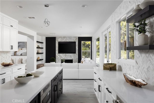 kitchen with decorative light fixtures, visible vents, light countertops, and white cabinetry