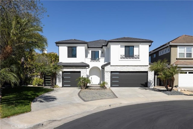 view of front of home featuring stucco siding, an attached garage, and driveway