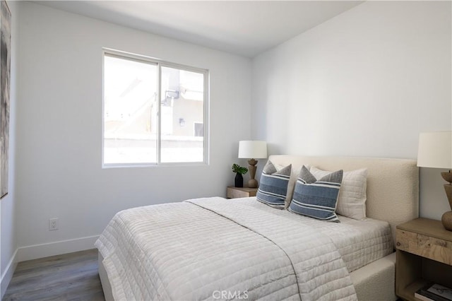 bedroom featuring baseboards and wood finished floors